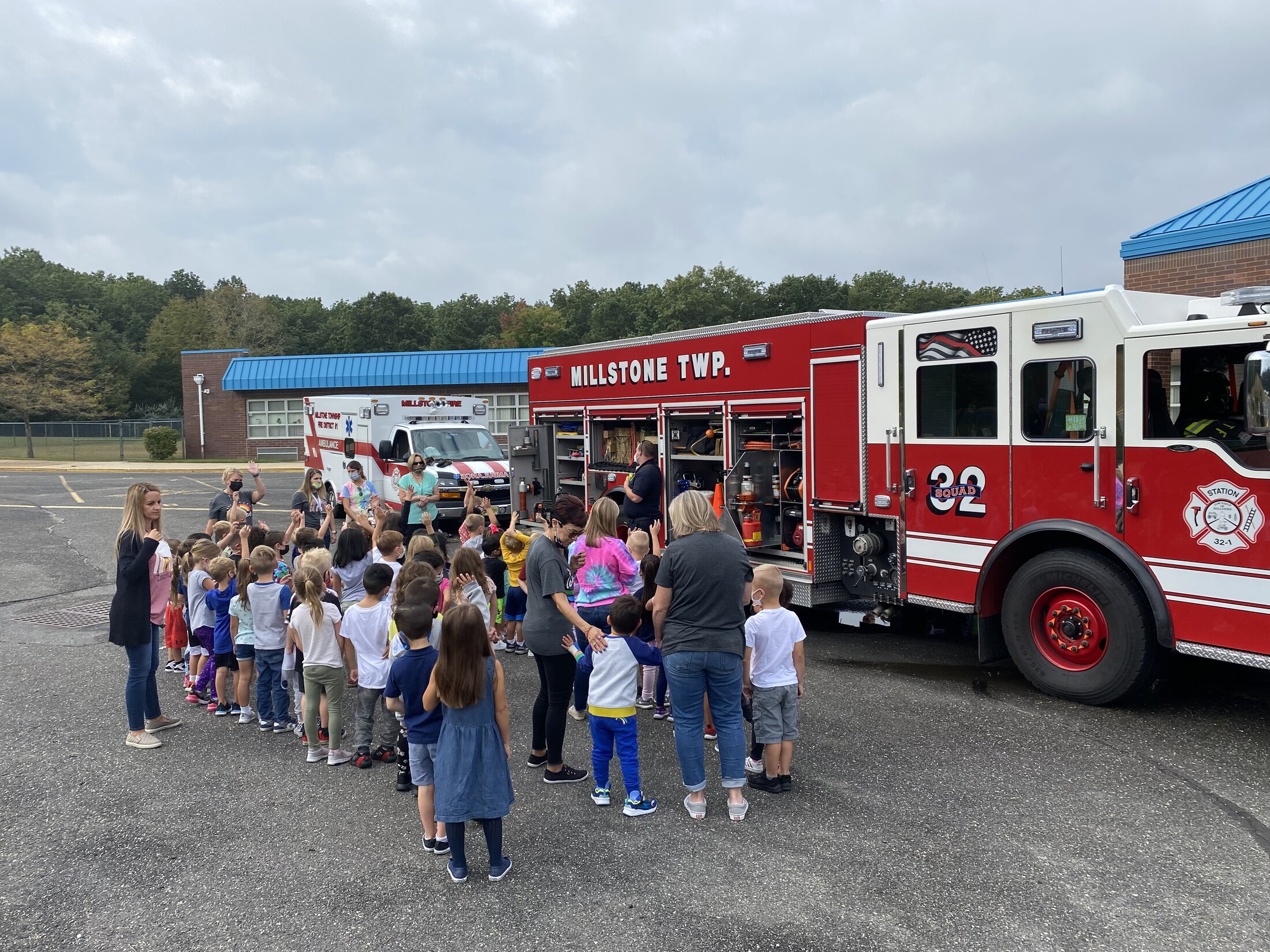 Students gather with firefighters beside Millstone Township fire apparatus during a public education visit