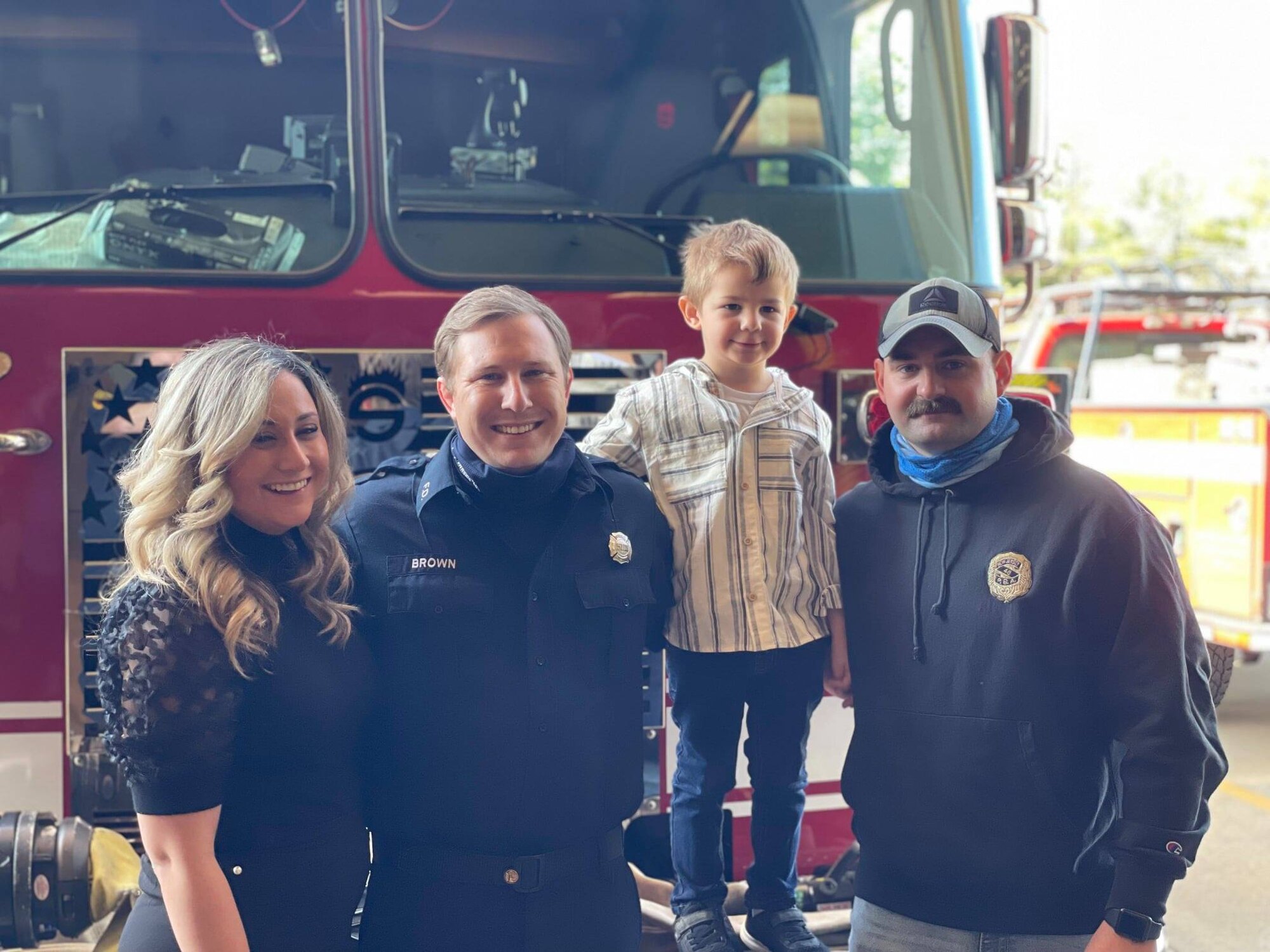Upper Freehold firefighters and a local family smiling together in front of a fire engine