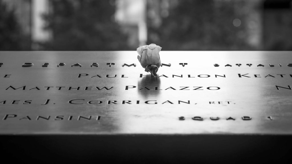 A white rose rests among engraved names at the National September 11 Memorial.